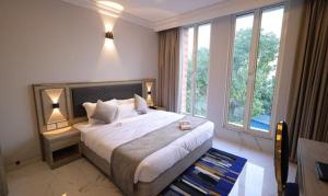 a bedroom with a large bed with a large window at FabHotel Prime Hampton By IC's in Noida