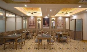 a restaurant with tables and chairs in a room at FabHotel Prime Hampton By IC's in Noida