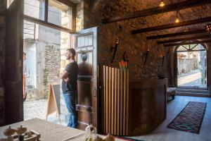 a man standing in a room with a refrigerator at Hotel Kapllani in Berat