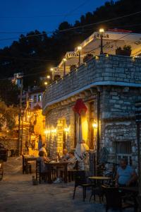a group of people sitting at tables in front of a building at Hotel Kapllani in Berat