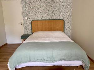 a bed with a wooden headboard in a bedroom at La chambre de Madeleine in Commercy