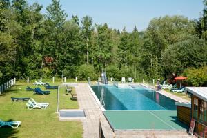 a swimming pool with chairs and a resort at Feriendorf Reichenbach - Bgm.-Martin-Str. 10/1 in Nesselwang