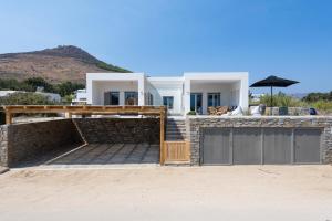 Exclusive Luxury Moca beachfront villa, Molos, Paros في Molos Parou: منزل على الشاطئ مع سياج