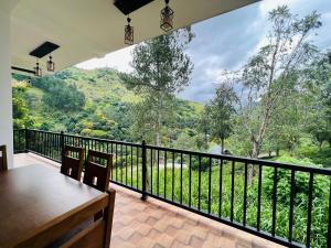 einen Balkon mit einem Tisch und Stühlen sowie Aussicht in der Unterkunft Ella Tea Heaven Villa in Ella