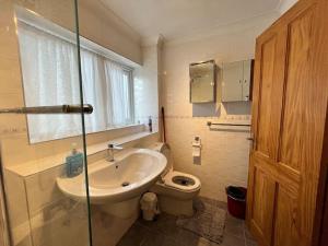 a bathroom with a sink and a toilet at Modern holiday home in Basildon