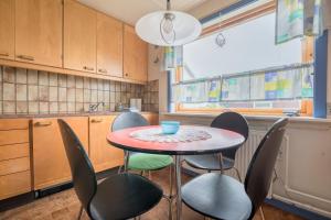 een kleine keuken met een tafel en stoelen bij Charming 2-bedroom home - 20min walk to city centre in Tórshavn