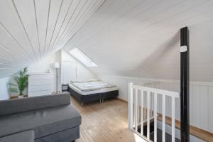 a attic room with a bed and a staircase at Ny og sentral leilighet in Kristiansand