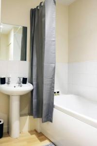 a bathroom with a sink and a shower curtain at 2 bed flat near Milton Keynes city centre in Milton Keynes