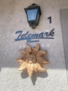 una señal en el lado de un edificio con una flor en Telemark Mountain Rooms, en Agordo