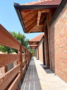 a walkway between two brick buildings with benches at Apartmani Vinarije IN in Mionica