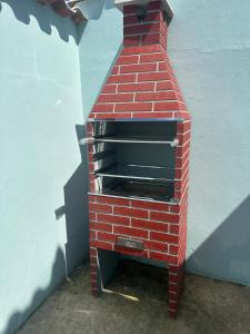 un horno de ladrillo sentado en el lateral de un edificio en Casa Onda Azul 1 en Saquarema