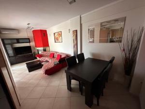 sala de estar con mesa negra y sofá rojo en Christos house-- Comfortable apartment with great view!, en Kavala