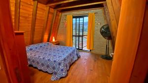 a bedroom with a bed in a room with a window at Complejo de Cabañas Valentino in Embalse