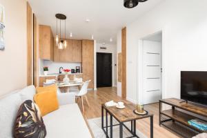 a living room with a white couch and a table at Perłowa Przystań Seaside Apartment by Renters in Sianozety