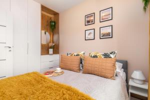 a bedroom with a bed with a yellow blanket on it at Perłowa Przystań Seaside Apartment by Renters in Sianozety
