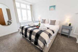 een slaapkamer met een bed met een zwart-witte deken bij Ocean Breeze - 1 MINUTE FROM THE BEACH - 10 MINUTE FROM BIC - FAST WI-FI - SMART TV in Bournemouth