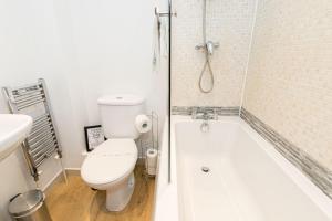 een badkamer met een toilet en een bad bij Ocean Breeze - 1 MINUTE FROM THE BEACH - 10 MINUTE FROM BIC - FAST WI-FI - SMART TV in Bournemouth