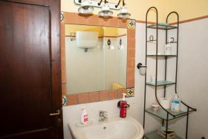 een badkamer met een wastafel en een spiegel bij Gattamelata, Historic Flat with Modern Comforts in Migliano +48 foto's