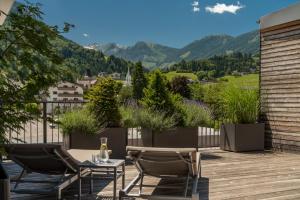 a patio with chairs and a table and mountains at Aparthotel Ursprung in Schladming