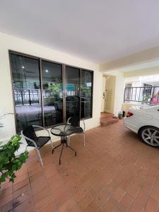 um pátio com uma mesa e cadeiras e um carro em Sukhumvit 31 Sweet Home 7 beds - up to 12 guests em Bang Kapi