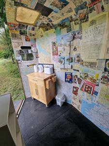 a room with a bathroom with a wall covered in posters at Glamping in style Emperor tent in Ifield