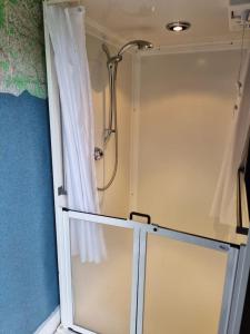 a shower in a bathroom with a shower curtain at Glamping in style Emperor tent in Ifield