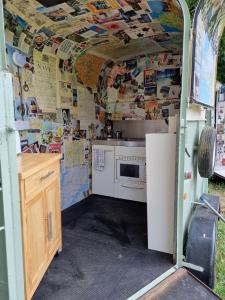 a small kitchen with a stove and a refrigerator at Glamping in style Emperor tent in Ifield