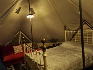 een slaapkamer met een hemelbed in een tent bij Glamping in style Emperor tent in Ifield