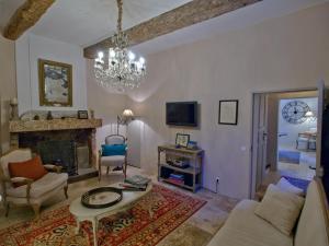 uma sala de estar com lareira e um lustre em Luxurious Provencal Village House, Walk to Village Pool em Rustrel