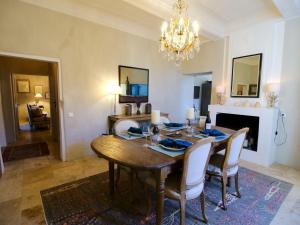 uma sala de jantar com uma mesa e um lustre em Luxurious Provencal Village House, Walk to Village Pool em Rustrel