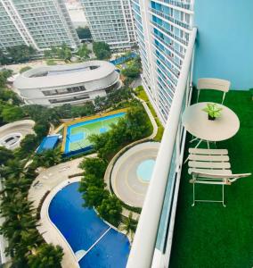 a balcony with a view of a pool and buildings at AZURE URBAN RESIDENCES PARAÑAQUE by M&D Maui Tower in Manila