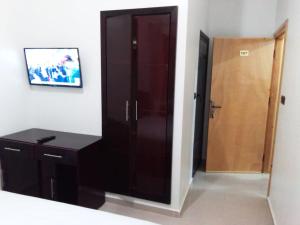 a bathroom with a black cabinet and a wooden door at HOTEL NASSIM AL-BAHR in Dakhla