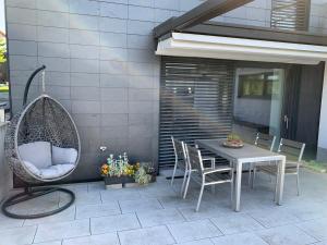 Ferienoase zwischen Rostock und Warnemünde في روستوك: فناء مع طاولة وكراسي ومرجيح