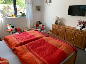 Ferienoase zwischen Rostock und Warnemünde في روستوك: غرفة نوم مع سرير مع بطانية حمراء عليه