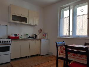 a kitchen with white cabinets and a stove top oven at Apartment Šula in Pljevlja