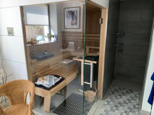 ein Bad mit einer Dusche, einem Tisch und einem Stuhl in der Unterkunft Ferienoase zwischen Rostock und Warnemünde in Rostock