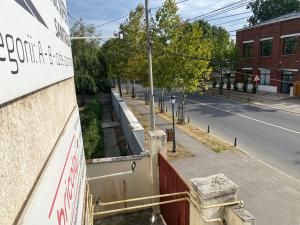 Vistas a una calle con un edificio y una carretera en Garsoniera 27mp - Camera - Baie - Bucatarie - Balcon en Mogoşoaia