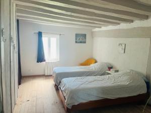 um quarto com 2 camas e uma janela em Maison en Colombage em Tilly