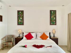 una camera da letto con un letto con rose rosse di Belharra Villas Seminyak a Seminyak