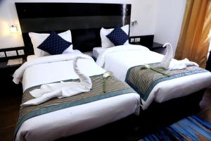 duas camas num quarto de hotel com toalhas em Posh Classic em Gurgaon