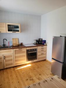 een keuken met een roestvrijstalen koelkast en houten vloeren bij Einkehr zur Rennstrecke in Hohnstein