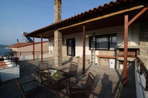 a patio with a table and chairs on a house at Villa Kirki in Iraklitsa