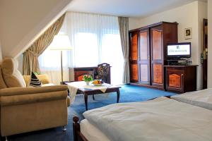 ein Hotelzimmer mit einem Bett und einem TV in der Unterkunft Hotel Stockhausen GbR in Schmallenberg