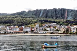 two boats in the water in front of a city at Cabañita en Playa Caolin in O Vicedo
