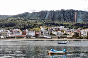 dos barcos en el agua frente a una ciudad en Cabañita en Playa Caolin, en O Vicedo