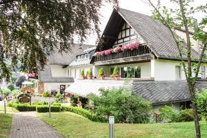 ein großes weißes Haus mit Blumen auf den Balkonen in der Unterkunft Hotel Stockhausen GbR in Schmallenberg