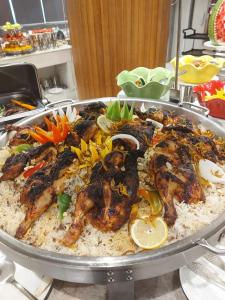 a tray of rice with chickens and vegetables on it at Taj Al-Wajh Hotel in Al Wajh