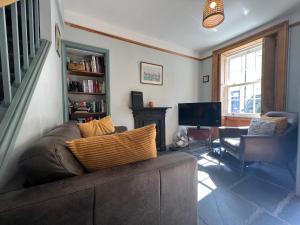 a living room with a couch and a television at The Old Locksmith Cottage, Ulverston - Lake District in Ulverston