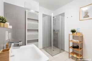 a bathroom with a shower and a white tub at Pineapple Apartments Dresden Zwinger I - 80 qm - 1x free parking in Dresden