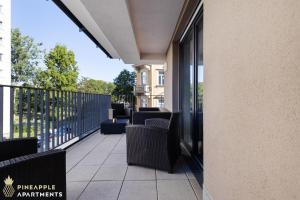 a balcony with chairs and tables on a building at PINEAPPLE APARTMENTS - Zwinger I - 80qm - 1x free parking in Dresden